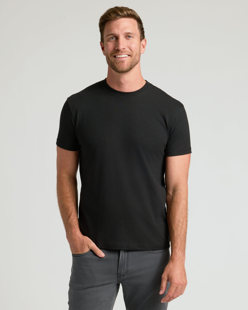 Man wearing The Staple Classic Crew Neck T-Shirt from 6-Pack, smiling.