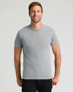 Man wearing The Staple Classic Crew Neck in heather gray, smiling.